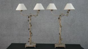 A pair of contemporary painted metal lamps, each with two branches, with entwined vine and ivory