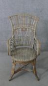 A wicker open arm conservatory chair, the back with cross and spiral detail, the arms with scrolling