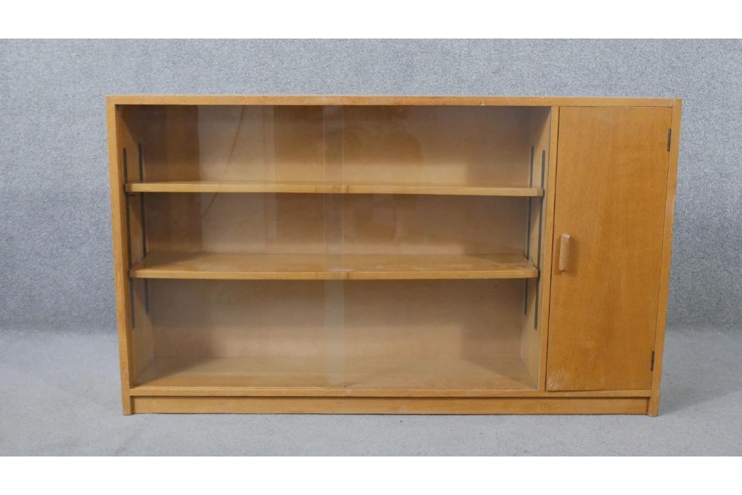 A 1960s light oak glazed Criterion bookcase, with two glass sliding doors enclosing shelves, one - Image 1 of 6