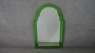 An Art Deco wall mirror, of rounded arch form, with a mirrored green bevelled frame. H.91 W.55cm