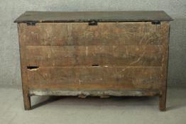 An 18th century oak mule chest, with a plank top over a fielded panel front, above three short