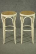 A pair of Thonet style painted bentwood bar stools, with caned seats. H.71cm.