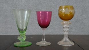 A Victorian cranberry glass wine glass, a green bubble glass with chicken stem and engraved with a