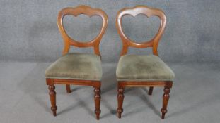 A pair of Victorian walnut balloon back dining chairs, upholstered in green velour, on turned legs.