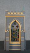 A scratch built matchstick model of a church tower, grey painted, with gothic arched stained glass