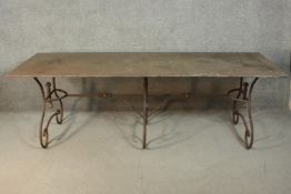 A French wrought iron table, possibly a baker's table, with a rectangular metal top, on scrolling
