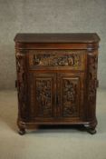 An early 20th century Chinese carved hardwood cabinet with central fitted drinks section. H.87 W.