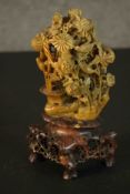 A Chinese early 20th century soapstone carving of chrysanthemums, rocks and birds on a carved darker