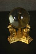 A gilt metal Egyptian style stand with cats and scarabs supporting a crystal ball. Dia.17cm