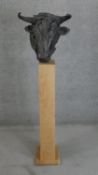 A large bronze moulded resin hollow head of a bull on an oak plinth base. H.150 W.25 D.35cm