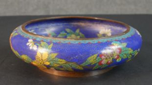A Meji period Japanese cloisonné enamel flower design on blue ground bowl. Cloud design to the base.