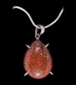 A POLISHED SAUROPOD DINOSAUR BONE CABOCHON MOUNTED IN SILVER PENDANT