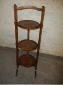 AN ANTIQUE OAK DUMB WAITED CAKE STAND