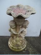 A CONCRETE BIRD BATH DEPICTING 3 CHERUBS