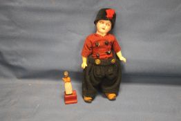A SMALL ANTIQUE BISQUE HEADED DOLL TOGETHER WITH A SMALL WOODEN FIGURE A/F