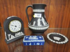 A WEDGWOOD BLACK JASPERWARE JUG, SMALL DESK CLOCK AND PIN DISH TOGETHER WITH A BLUE DIP LIDDED