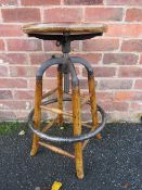 AN INDUSTRIAL STYLE WOOD AND CAST STOOL