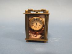 A MODERN MINIATURE CARRIAGE CLOCK WITH PLASTIC PANELS DEPICTING NUDE FEMALE IMAGES