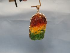 A CARVED DECORATIVE THREE COLOUR PENDANT WITH WHITE METAL AND 925 SURROUND