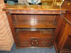 A CARVED REPRODUCTION OAK OPEN BOOKCASE WITH CUPBOARD BELOW W-85 CM