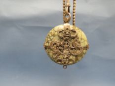 AN EASTERN PENDANT WITH WHITE METAL OVERLAY WITH BUDDHA AND DRAGON DETAIL WITH RETICULATED LINK