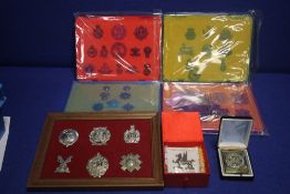 A COLLECTION OF MILITARY CAP BADGES AND A BELT BUCKLE