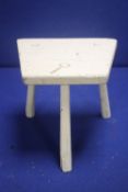 AN ANTIQUE WHITE PAINTED MILKING STOOL