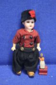 A SMALL ANTIQUE BISQUE HEADED DOLL TOGETHER WITH A SMALL WOODEN FIGURE A/F