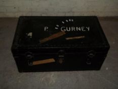 A BLACK WOODEN TRAVEL TRUNK