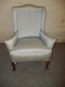 AN ANTIQUE UPHOLSTERED WING BACK CHAIR WITH QUEEN ANNE LEGS