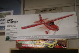 A SUPER DECATHLON REMOTE CONTROL AEROPLANE TOGETHER WITH A BOXED SCALEXTRIC SET