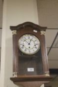 A WOODEN CASED WALLCLOCK