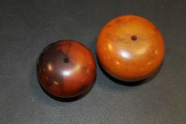 TWO LARGE AMBER TYPE BEADS