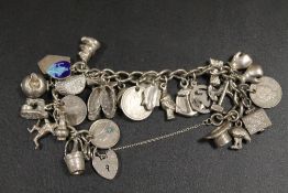 A HALLMARKED SILVER CHARM BRACELET WITH MANY CHARMS - APPROX WEIGHT 93.9 G