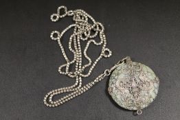 AN EASTERN PENDANT WITH WHITE METAL OVERLAY WITH BUDDHA AND DRAGON DETAIL WITH RETICULATED LINK