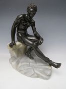 A 19TH CONTINENTAL BRONZE STATURE OF A NAKED MAN SEATED UPON A ROCKY OUTCROP, wearing sandals with