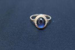 A HALLMARKED 9 CARAT GOLD RING, set with a cabochon sapphire style stone, approx weight 1.6g, ring
