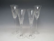 TWO STUART CRYSTAL STRATA PATTERN CHAMPAGNE FLUTES DESIGNED BY JASPER CONRAN, together with two