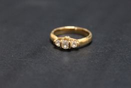 A UNUSUAL HALLMARKED 18 CARAT GOLD DIAMOND TRILOGY RING, set with graduating brilliant cut diamonds,