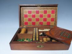 A VINTAGE WOODEN GAMES BOX AND CONTENTS, the contents to include miniature bone dominoes, chess