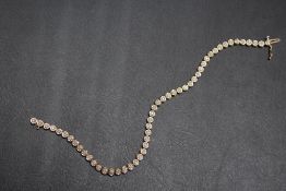 A HALLMARKED 9 CARAT GOLD DIAMOND SET TENNIS BRACELET, set with small diamond accents, approx weight