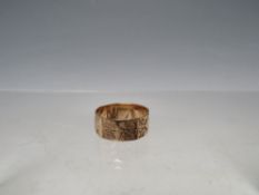A HALLMARKED 9CT GOLD RING WITH ENGRAVED DESIGN, being panel effect shape, size Q ½, approx 2.67 g