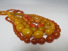 A COLLECTION OF AMBER AND LUCITE VINTAGE BEADS, comprising three necklaces and one braceletCondition