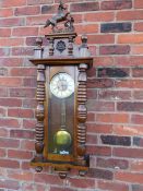 A KIENZLE GONG STRIKE VIENNA WALL CLOCK, the case having bold turned pillars, mahogany veneered