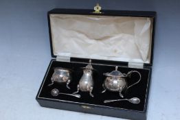 A CASED HALLMARKED SILVER THREE PIECE CRUET SET - BIRMINGHAM 1933, together with two salt spoons,