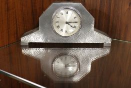 AN ARTS AND CRAFTS STYLE HAMMERED EFFECT PEWTER CASED MANTEL CLOCK