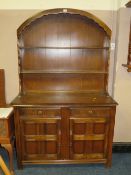 A TRADITIONAL OAK DOMED DRESSER