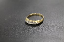 AN UNMARKED YELLOW METAL FIVE STONE DRESS RING - APPROX WEIGHT 2 G