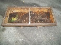 A SMALL CAST IRON CHICKEN FEEDER TROUGH