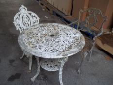 A CAST IRON GARDEN TABLE AND CHAIR WITH A MATCHED EXTRA CHAIR
